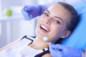 woman in a dentist chair and dentist holding tools, about splendid dental atascocita