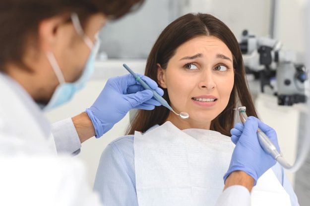 a woman struggling with her dentophobia