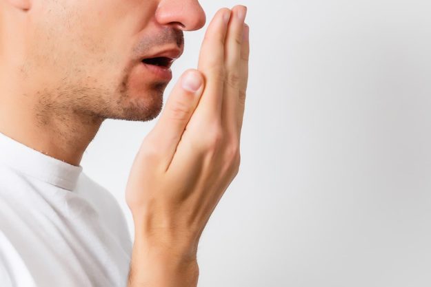 a man checking for halitosis