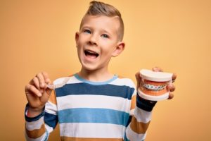 a young boy smiling with orthodontics