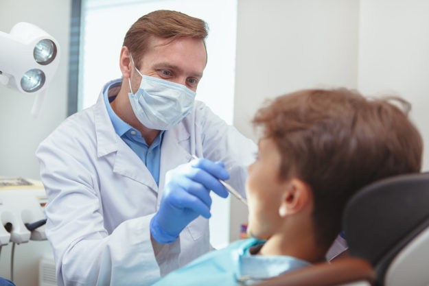 a family dentist and pediatric dentist provides dental services to a young boy